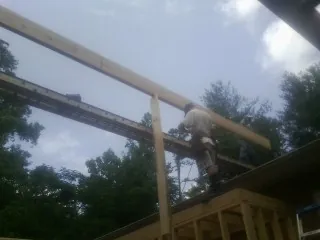 Carpenter setting a ridge beam over a new addition frame — Ice Dam Removal by Roofing Brothers in Reseda