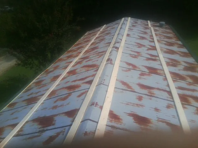 Rusted metal roof panels with new wood purlins before replacement — Storm Damage Roof Repair in Reseda by Roofing Brothers