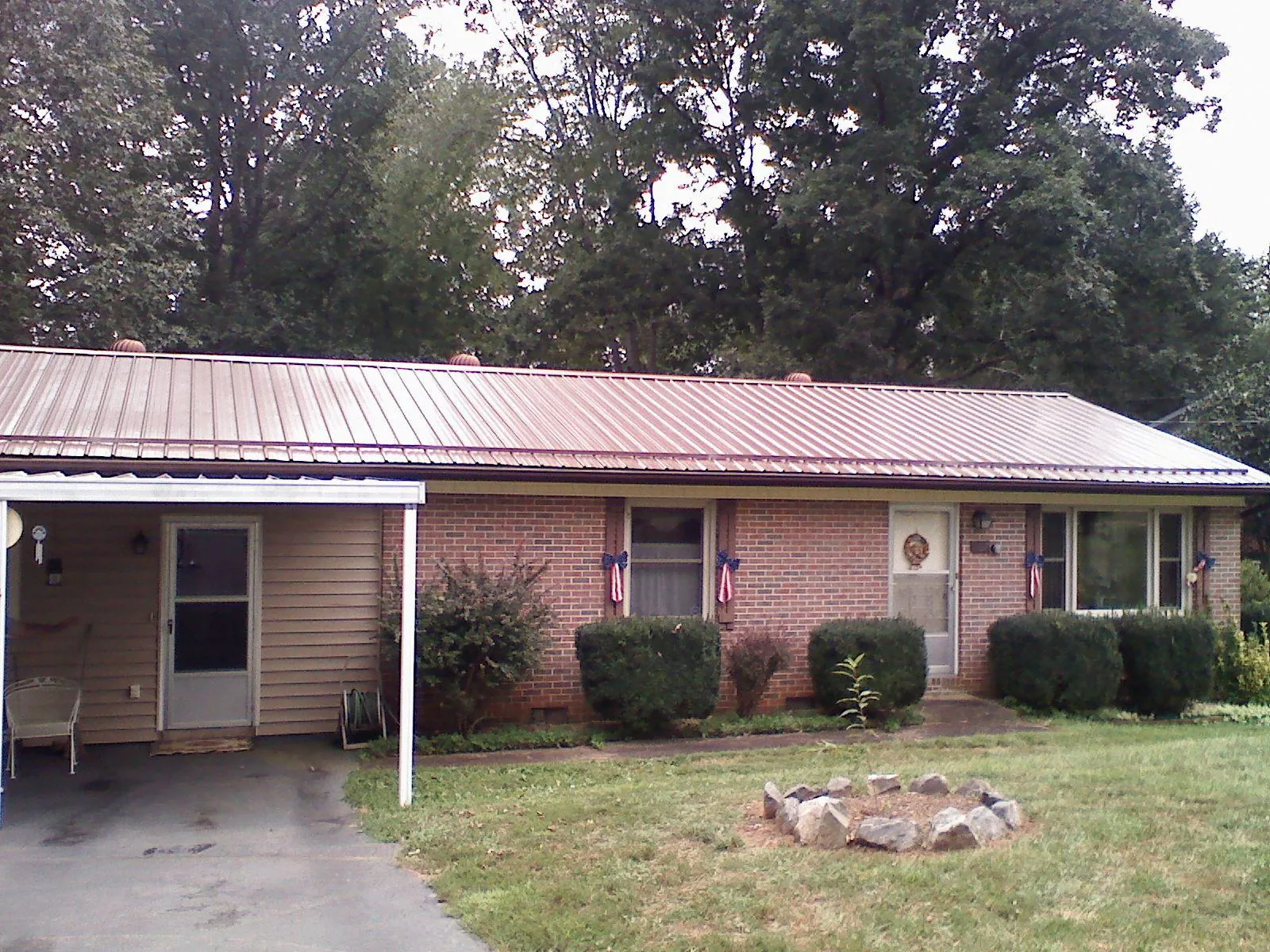 Bronze metal roof and carport on a brick ranch home — Roof Repair work by our crew in Reseda